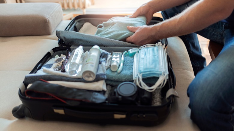 person packing suitcase