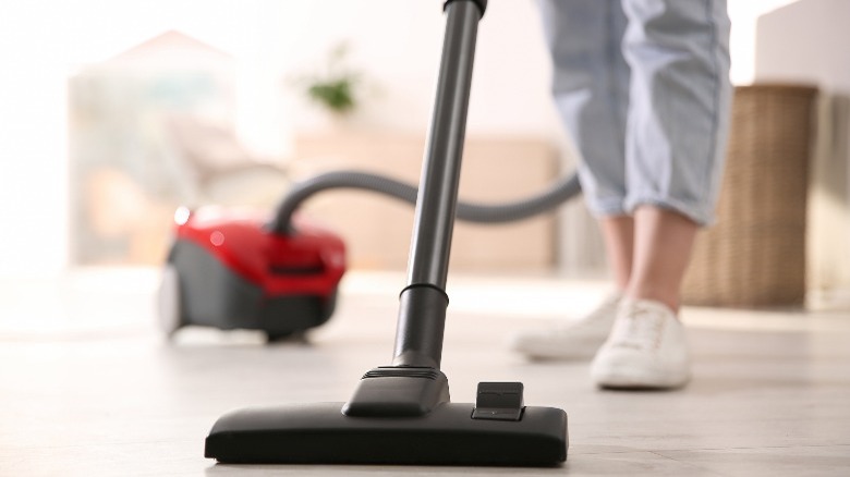 Person using red vacuum cleaner