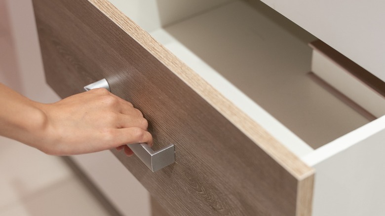 Hand pulling a drawer open