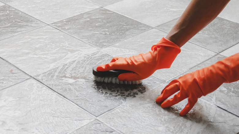 person cleaning floors with scrub brush