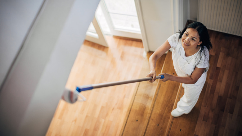 woman painting door frame