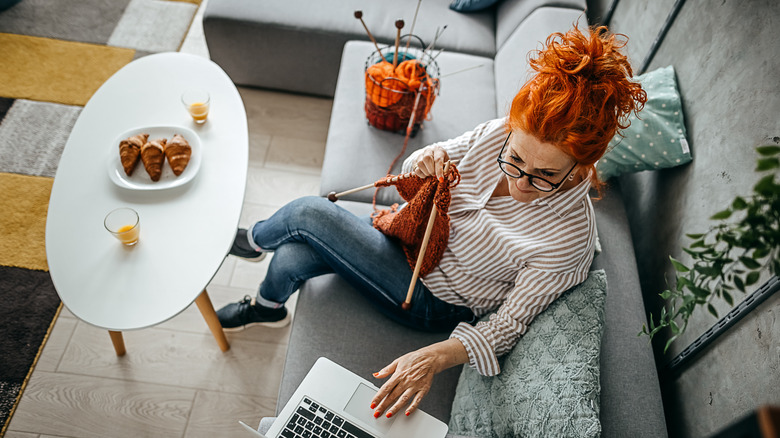 woman knitting on couch