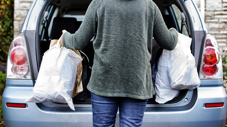 woman loading car with groceries