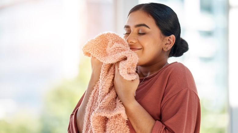 woman smelling clean towel