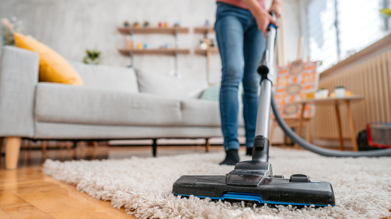 person vacuuming rug