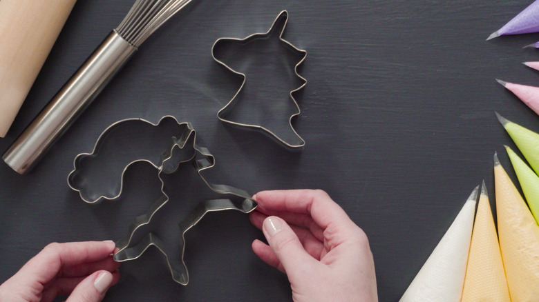 hand touching cookie cutters