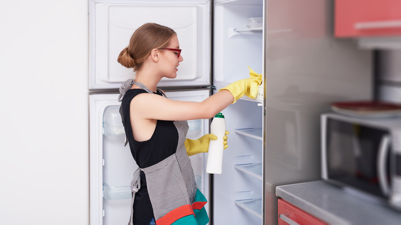 Woman cleaning inside a refrigerator