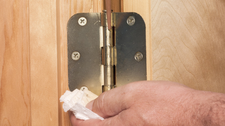 Oiling door hinge with paper towel