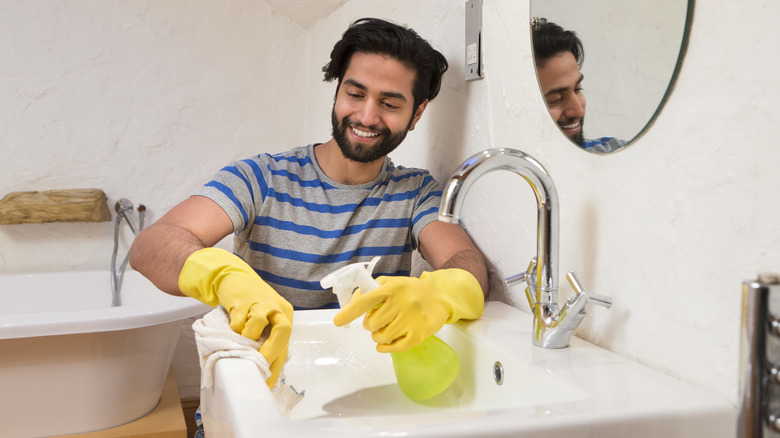 man cleaning bathroom sink