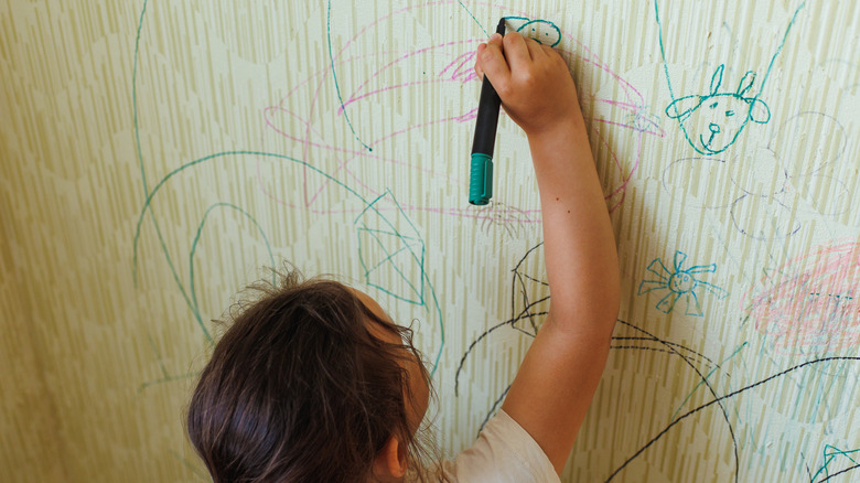 child drawing on the wall