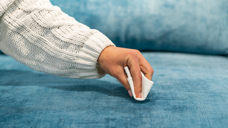 Using cloth to clean sofa