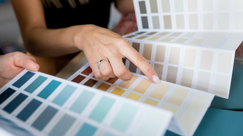 woman's hand pointing at paint swatches