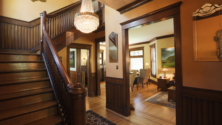 home foyer with dark wood staircase and wainscoting