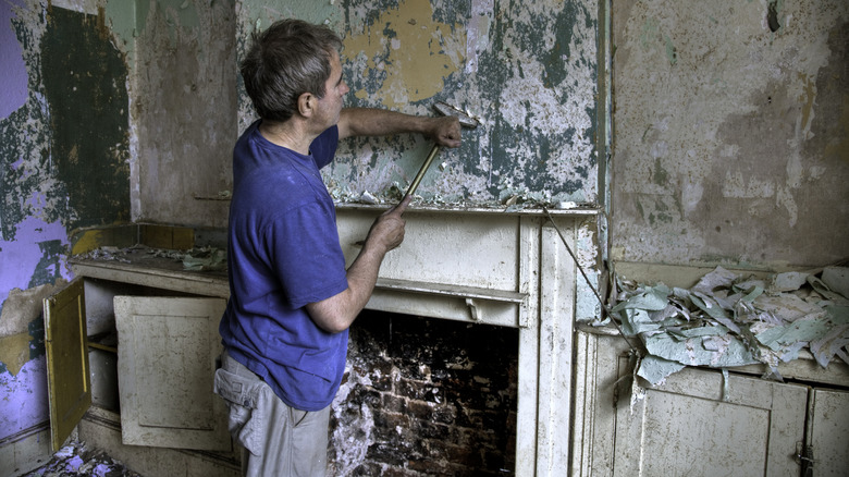 man removing fireplace old mantel