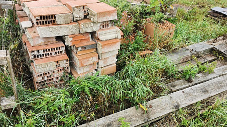 messy garden with wood and bricks