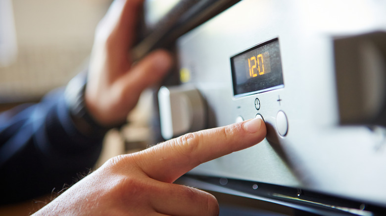 A finger pushing a button on an appliance