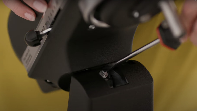 A close up of screwdriver loosening screw on KitchenAid