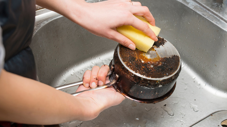 Person washing rusty pan