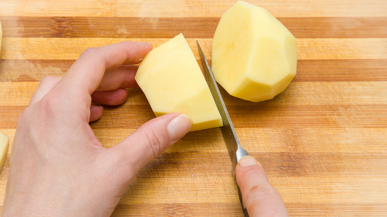 Person cutting a potato