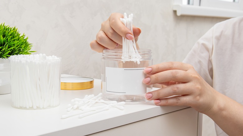 Person placing earbuds in jar