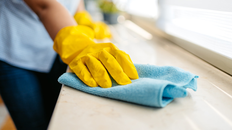 Person cleaning with microfiber cloth