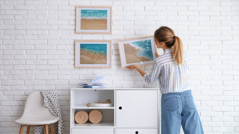 Woman hanging artwork