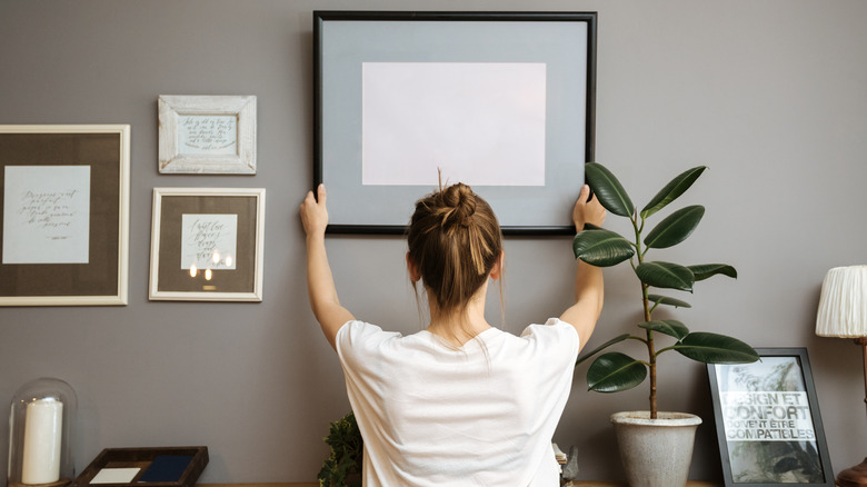 Woman hanging a piece of art