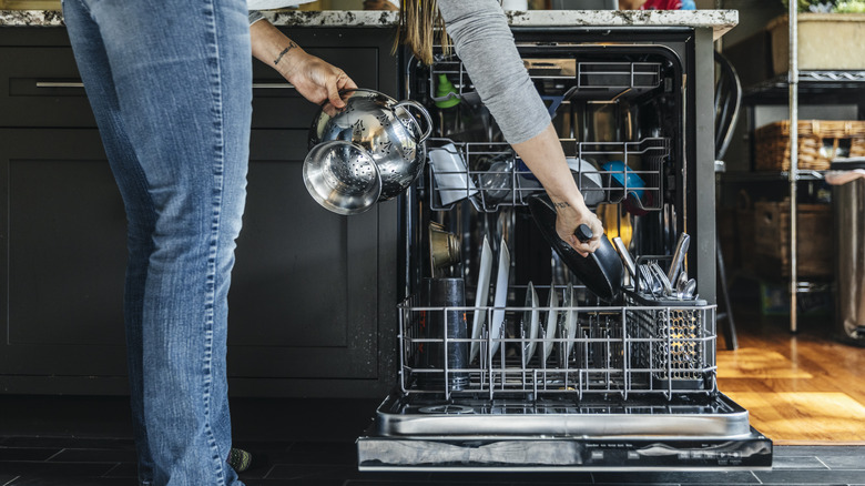 A woman taking dishes out of a dishwasher.