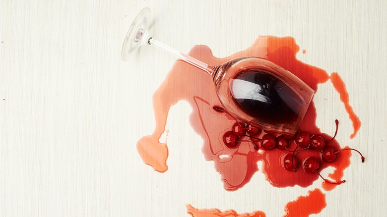 Wine and cherries spill on countertop