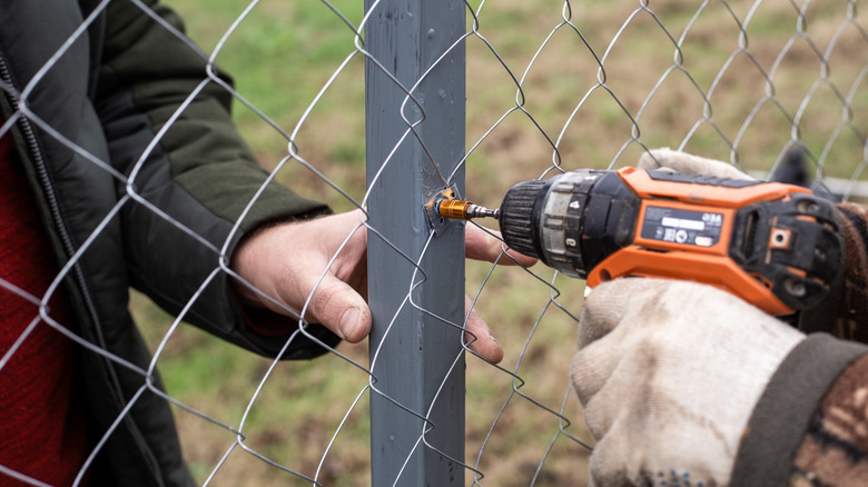 Workers installing a chain link fence