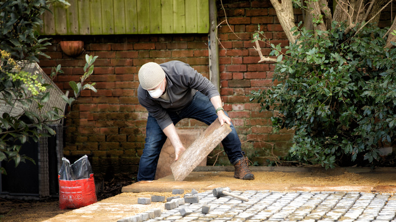 Person laying down patio pavers