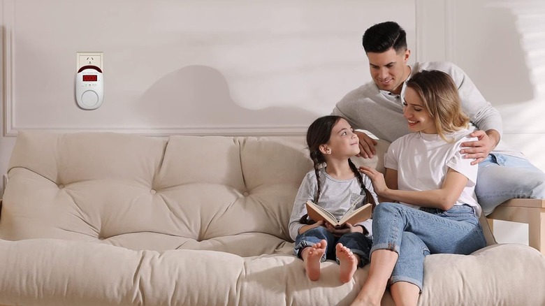 A family on the couch by a gas detector