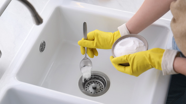 pouring baking soda in sink