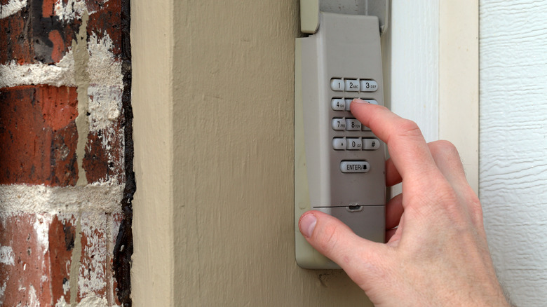 person pressing keys on a garage door keypad