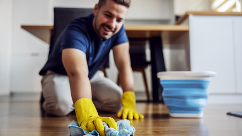 man cleaning wood floor