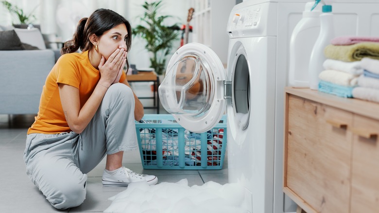 woman with overflowing washing machine