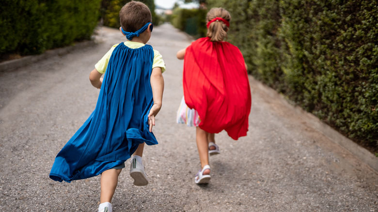 children in red and blue capes