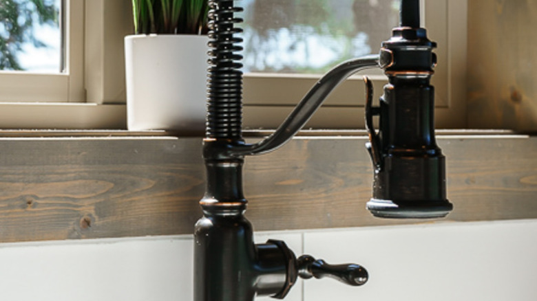 Wood trim along tile backsplash behind a sink