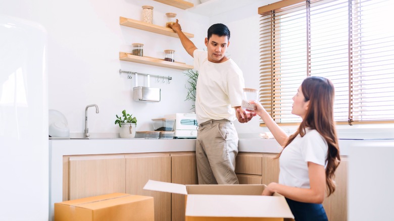 Couple putting jars on shelves