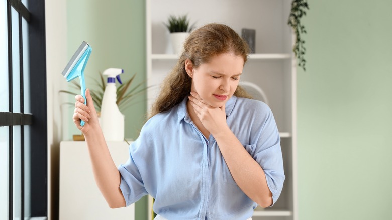 Woman coughing while cleaning