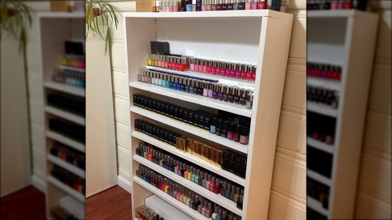 nail polishes on white bookcase