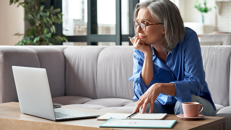 person looking at laptop contemplatively