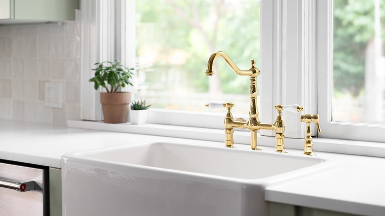 White apron sink with gold faucet