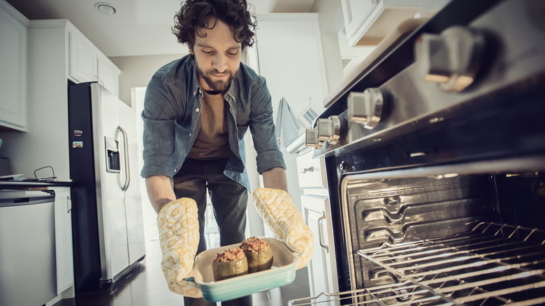 Man putting dish into oven