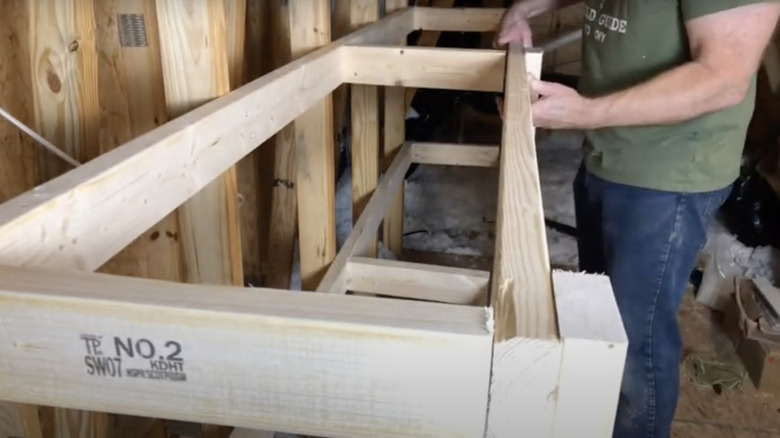 person building shelving in attic