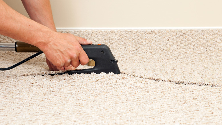 Person joining two sections of carpet