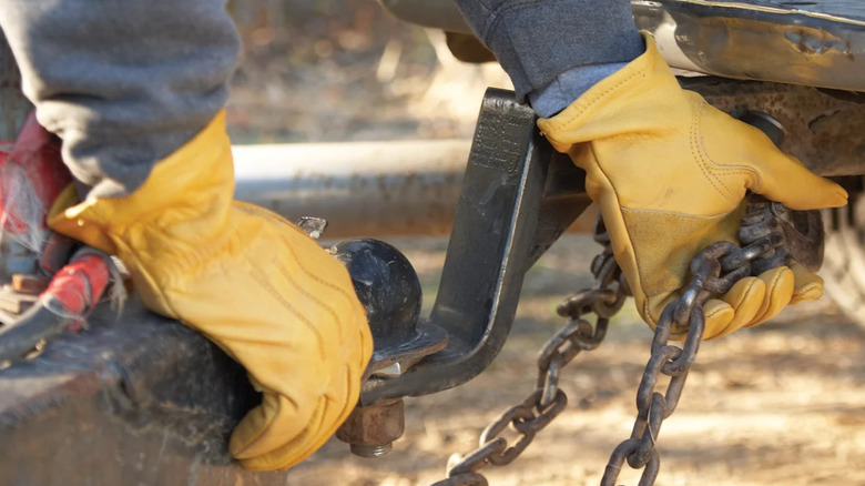 yellow gloved hands hitching trailer