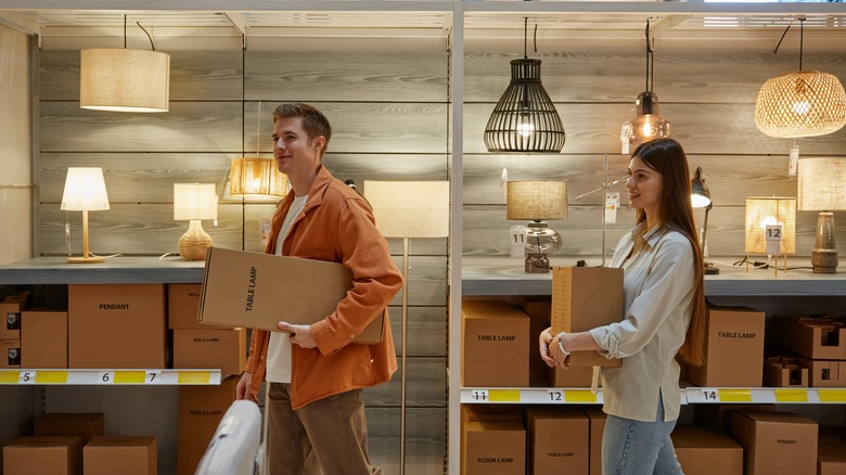 couple walking through store aisle with lamps