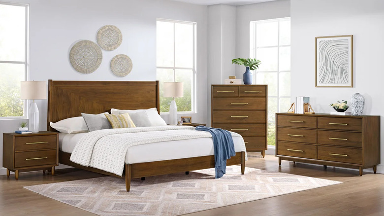 A medium wood bedroom set in a room with a neutral color scheme