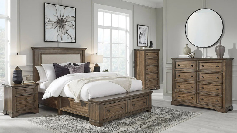 A white bedroom with a medium wood furniture set